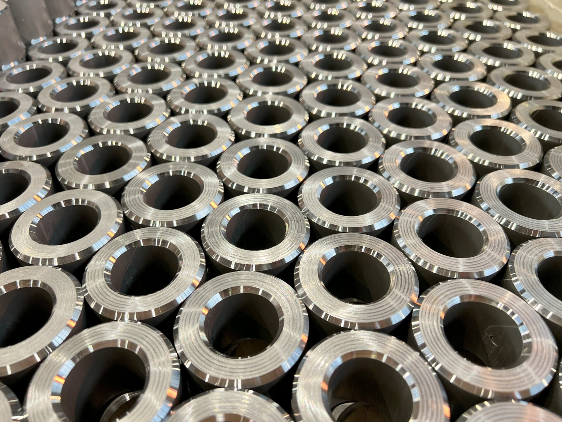 Dozens of chamfered-edge toroidal cores with precise dimensions, ready for assembly in electronic devices. Perfect quality for transformers and electromagnetic applications.